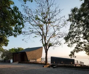 A minimalist residential exterior with wooden walls and stone accents.