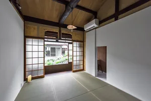 A minimalist residential interior featuring wooden walls, paper floors, and a paper air conditioning unit.