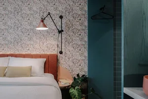 A modern bedroom featuring a floral patterned wallpaper and a comfortable bed.