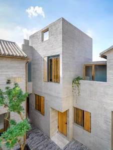 Modern, minimalist house with concrete exterior and wooden accents.