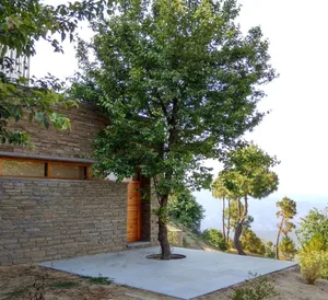 A modern house with stone, concrete, and wooden elements