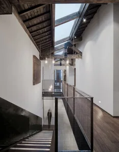 Staircase with wood and concrete materials and a skylight in the ceiling.