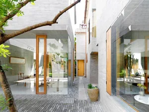 Contemporary interior design featuring a minimalist concrete space with large windows and a central courtyard.