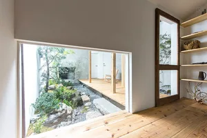 Modern living space featuring wooden floors, glass walls, and stone elements.