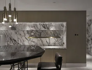A modern kitchen featuring a marble countertop and backsplash.