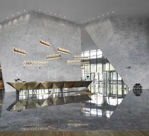 Polished concrete lobby area with geometric reception desk and modern lighting fixtures.