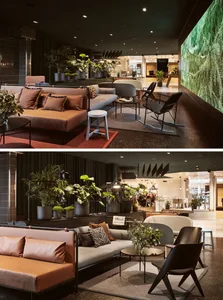 Modern lobby interior with concrete walls, contemporary seating, and potted plants