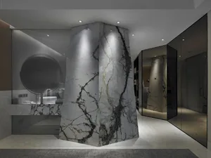 A modern bathroom interior featuring a tall, monolithic marble pillar as a centerpiece.