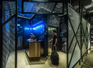 A modern office space with metallic finishes, glass partitions, and digital displays.