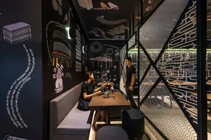 A modern restaurant interior with black walls and a chalkboard wall