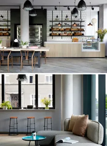 A modern restaurant with wooden tables, concrete flooring, and industrial lighting.