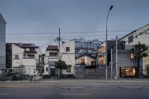 A city street corner featuring a modern retail shop with brick walls, glass windows, and concrete flooring.