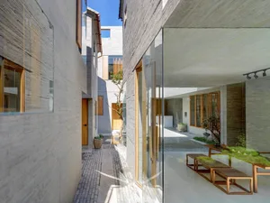 Interior of a minimalist hallway featuring concrete, glass, and wooden elements.