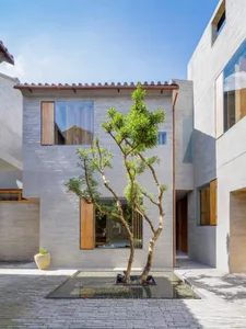 A modern concrete building with large windows and a central courtyard.
