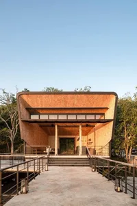 Modern building with copper-colored cladding and large windows.