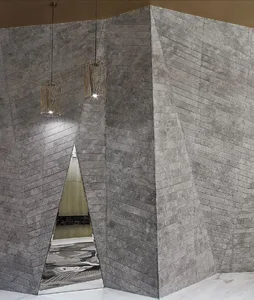 A modern industrial living space with concrete walls and a reflective mirror.