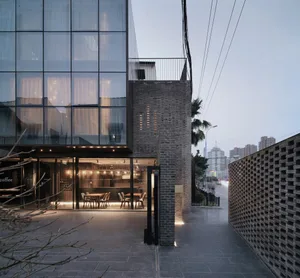 Modern industrial storefront with metal, glass, brick, and concrete elements.
