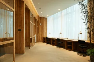 現代辦公空間，設有木質工作站、座位以及牆上的時鐘。