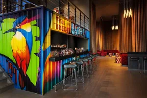 Contemporary bar interior with vibrant graffiti mural and seating area.