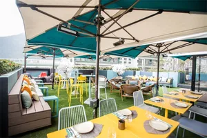 Outdoor cafe with industrial design elements, including concrete flooring and metal furniture.