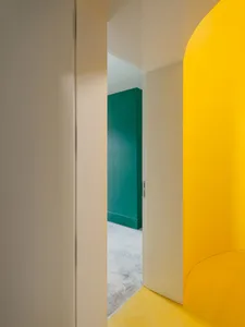 A minimalist interior with vibrant yellow and green walls and a white door.