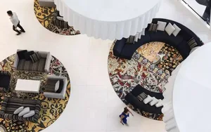 Modern hotel reception area featuring carpet and cushions