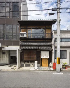 傳統日式建築立面，搭配木製百葉窗與混凝土基座