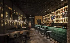 Industrial-themed restaurant or bar interior with exposed brick walls, wooden floors, and metal decor.