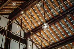 Industrial-style ceiling design featuring metal trusses and hanging light fixtures