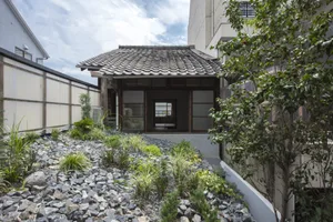 A minimalist house with stone exterior, glass windows, and wooden accents.