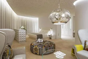 A modern bedroom suite featuring a white fabric headboard and floor-length curtains.
