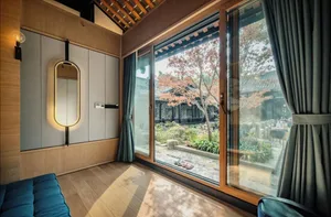 Modern luxury living room with a wooden floor and large windows overlooking a courtyard.