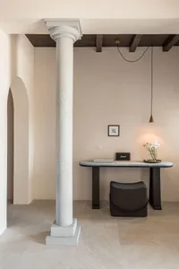 極簡室內設計，展示混凝土與大理石材質的玄關桌，搭配吊燈與花卉。