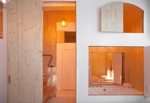 A modern bathroom featuring wooden walls and a wooden bathtub.