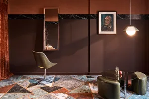A modern living room featuring terrazzo flooring, marble accents, and leather furniture.