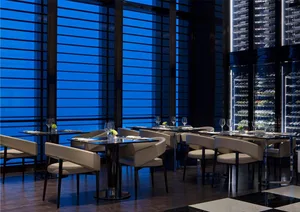 Modern restaurant interior with glass walls and metal accents, showcasing sleek and contemporary design features.