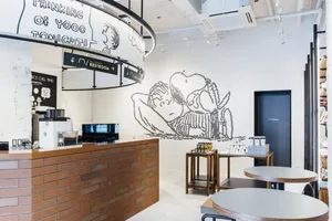 A modern coffee shop interior with exposed brick walls and laminate flooring.
