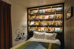 A modern bedroom with wooden shelves featuring Snoopy and Charlie Brown memorabilia.