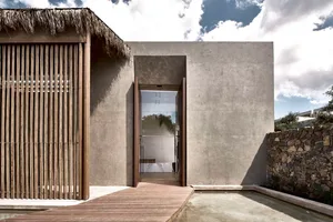 A modern house with a concrete facade and wooden walkway.