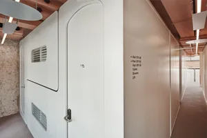 Office interior with modern, metal-clad walls and white doors.