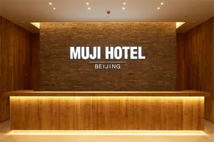 Modern wooden reception desk in the Muji Hotel Beijing lobby.