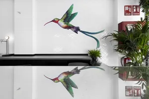 A minimalist wall art featuring a colorful hummingbird in flight against a white background.