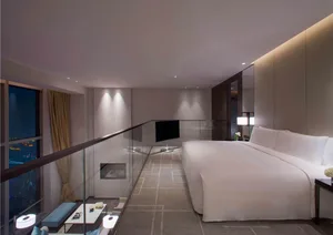 Modern minimalist bedroom with a white bed, glass railing, and floor-to-ceiling windows overlooking a cityscape.