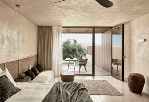 Modern minimalist bedroom with concrete walls, floor, and ceiling.