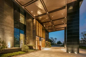 A modern hotel entrance with metallic walls and large glass windows.