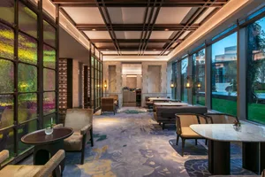 Modern, luxurious restaurant interior with elegant seating, marble tables, and stained glass windows.