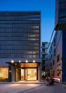 A modern glass exterior of a hotel building at dusk.