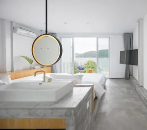 Modern residential bedroom featuring concrete, glass, and wood elements.