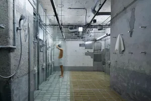 A minimalist, industrial-style bathroom with exposed concrete walls and a walk-in shower.