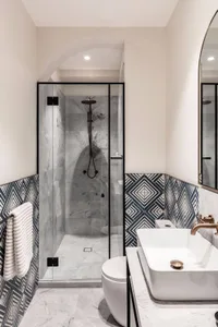 Modern minimalist bathroom featuring marble finishes and geometric tile patterns.